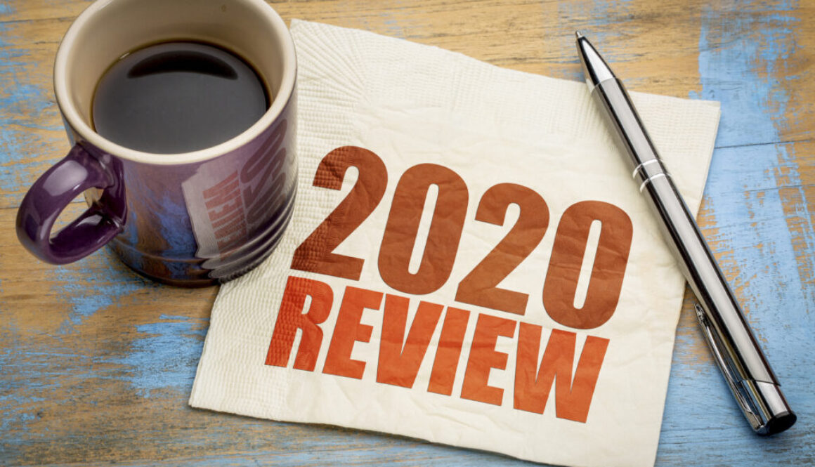 2020 year review text on a napkin with a cup of coffee, end of year business concept