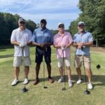 four-men-holding-golf-clubs