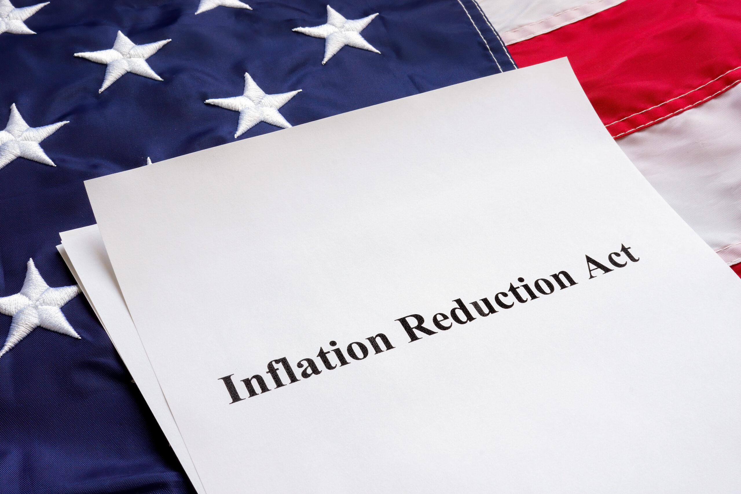 Papers with the Inflation Reduction Act and US flag.